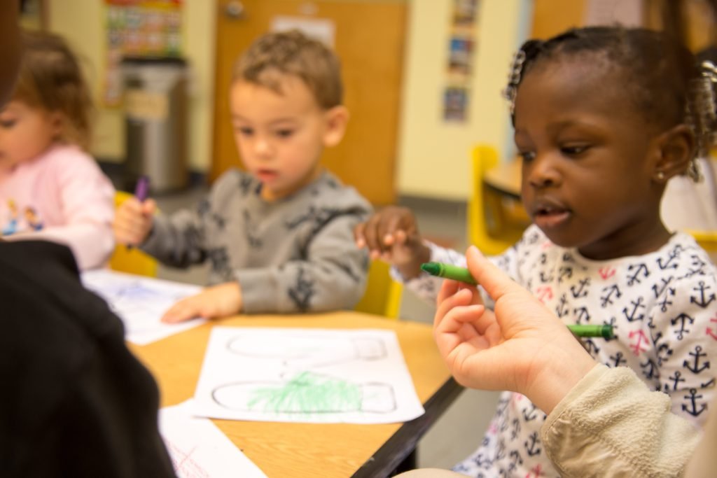 Children drawing together at a classroom table